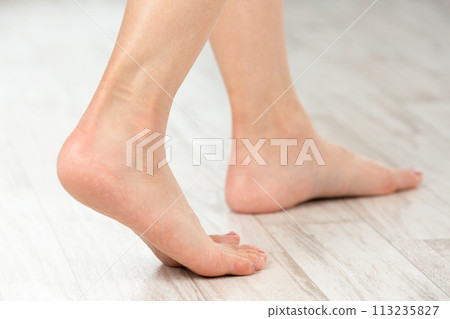 A young woman walking barefoot. 113235827