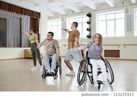Modern wheelchair dance team having rehearsal in spacious studio, long shot, copy space Modern wheelchair dance team having rehearsal in spacious studio, long shot, copy space 113235915