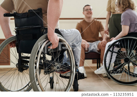 Selective focus shot of wheelchair dancers and their coaches relaxing and chatting during break time 113235951