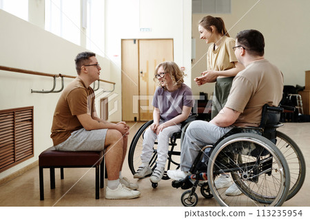 Goup of wheelchair dancers and their trainers spending break time together chatting and laughing 113235954