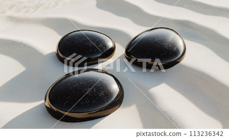 Background of white sand and three black round stones 113236342