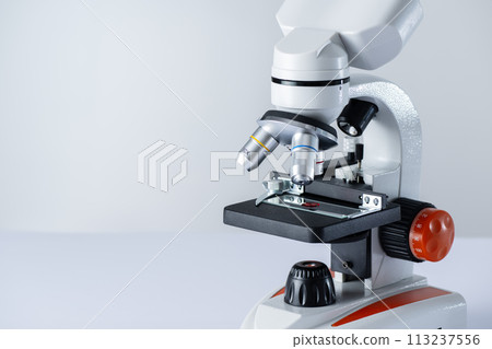 Microscope on white background with copy space. Blood sample on a glass under microscope. HIV test research. Microscope on white background with copy space. Blood sample on a glass under microscope. HIV test research. 113237556