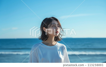 A woman standing by the sea A woman standing by the sea 113238001