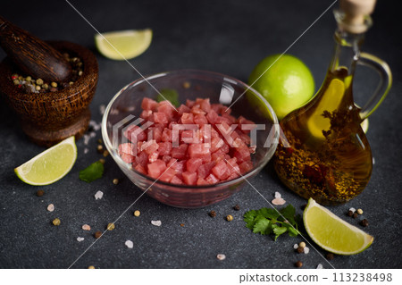 Sliced and chopped tuna fillet in glass bowl at domestic kitchen cooking traditional tartare 113238498