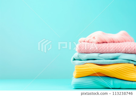 Stack of clean towels in laundry wicker basket on blue background. The towels showcasing their soft and fluffy textures 113238746