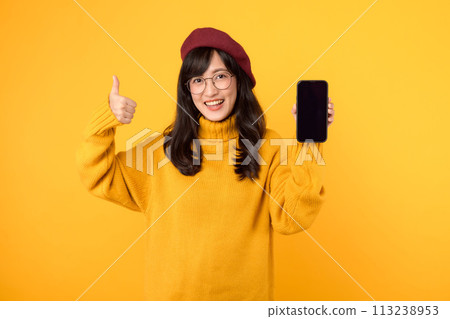 Japanese, Korean, and Chinese ethnicities united, showing thumbs up while using a smartphone against a vibrant yellow background, dressed in red beret and eyeglasses. 113238953