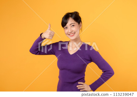 Positive and successful young woman 30s flashing a thumbs-up sign with a cheerful smile. A portrait of confidence and happiness. 113239047