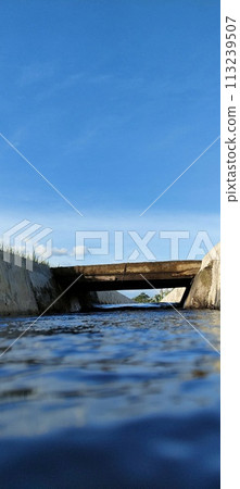 Small river on the edge of rice fields during the day Small river on the edge of rice fields during the day 113239507