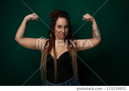 Woman With Long Hair and Tattoos Posing for a Picture 113239932