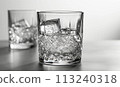 Transparent glass with clear drink and ice cubes. 113240318