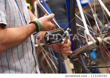 Close up of bicycle mechanic in workshop in the repair process. High quality photo Close up of bicycle mechanic in workshop in the repair process. High quality photo 113240592