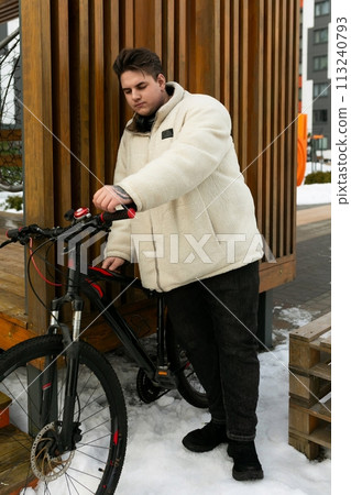 Young European man with a bicycle in an urban environment Young European man with a bicycle in an urban environment 113240793
