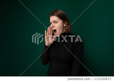 Woman in Black Shirt Holding Hand to Mouth Woman in Black Shirt Holding Hand to Mouth 113240871
