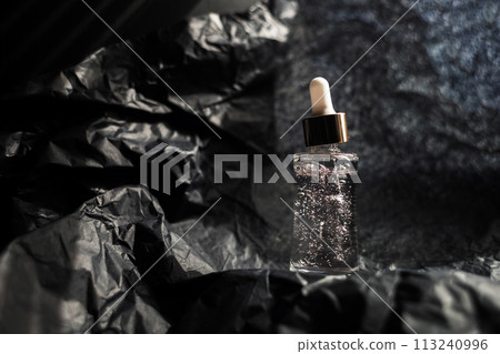 Jar with collagen, peptides, glycerin and antioxidants on a black background. The concept of helping women care for their decollete area. 113240996