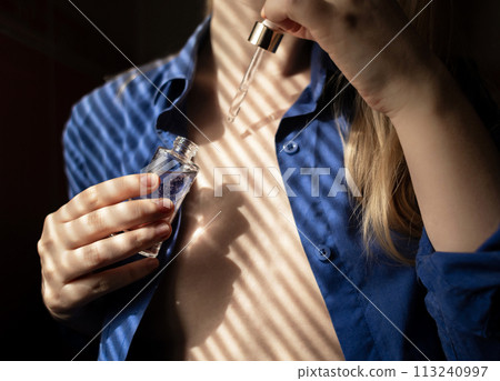 Breast serum. The girl shows her cleavage, which she will take care of with collagen, peptides, hyaluronic acid, glycerin, antioxidants, vitamins, and retinol. Prevention of breast stretch marks 113240997