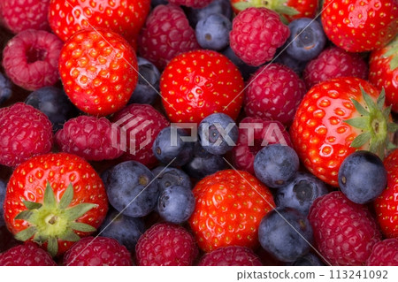 Variety of berries - strawberries, blueberries, raspberries scattered 113241092