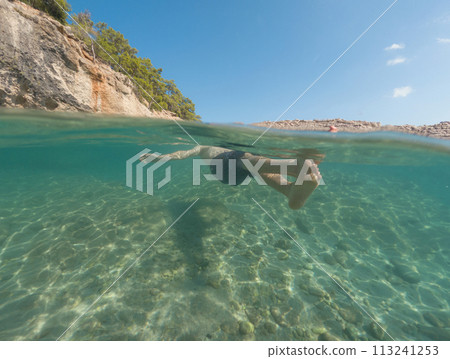 Young male on holidays enjoy floating on a crystal clear water beach of Antalya Turkey. Man swimming with open arms. Relax and tranquility Young male on holidays enjoy floating on a crystal clear water beach of Antalya Turkey. Man swimming with open arms. Relax and tranquility 113241253