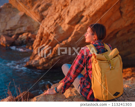 Young woman hiking on rocky beach in Spain, Benidorm. Watching the choppy sea and the bay. traveler enjoying freedom in serene nature landscape Young woman hiking on rocky beach in Spain, Benidorm. Watching the choppy sea and the bay. traveler enjoying freedom in serene nature landscape 113241303