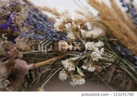 wreath of dried herbs Poppy spikelets of wheat predominance of blue dried herbs in decoration on the wall we will weave a wreath With love, handmade art Dried wildflowers create the atmosphere. wreath of dried herbs Poppy spikelets of wheat predominance of blue dried herbs in decoration on the wall we will weave a wreath With love, handmade art Dried wildflowers create the atmosphere. 113241780