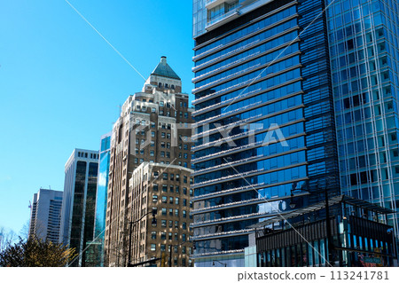 beautiful glass buildings skyscrapers rising into the blue sky without clouds Vancouver cherry blossoms in spring the camera slowly captures the cityscape office buildings the latest technology beautiful glass buildings skyscrapers rising into the blue sky without clouds Vancouver cherry blossoms in spring the camera slowly captures the cityscape office buildings the latest technology 113241781