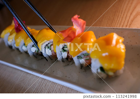 Close-up, mango sushi set on white clay plate white background Mango and Cream Cheese sushi flavor 113241998