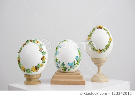 three eggs on special wooden stands on a white background lavender background postcard baner calendar empty space holiday easter eggs embroidery ribbons on eggshell krashanka 113242013