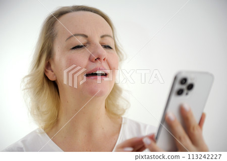 vision problems need glasses woman squinting looking at phone pushing it away farsightedness myopia smiling with mouth open reading news message on internet playing game middle age closeup vision problems need glasses woman squinting looking at phone pushing it away farsightedness myopia smiling with mouth open reading news message on internet playing game middle age closeup 113242227