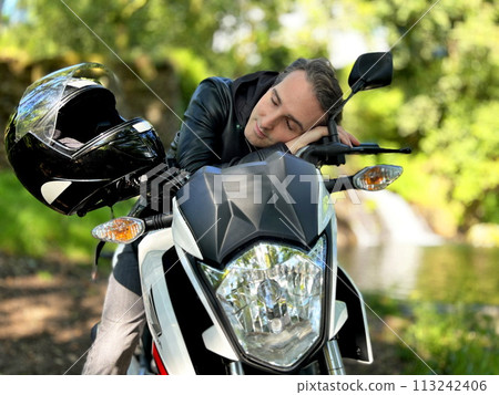 in nature in tranquility, a man fell asleep on a motorcycle, can be used to advertise relaxation on a trip, the photo adjusts to relaxation in nature in tranquility, a man fell asleep on a motorcycle, can be used to advertise relaxation on a trip, the photo adjusts to relaxation 113242406