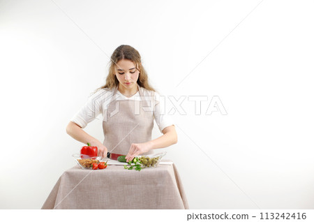 Cook holds knife in hand and cuts on cutting board green onions for salad or fresh vegetable soup with vitamins. Raw food and vegetarian recipe book in modern society popular concept. Cook holds knife in hand and cuts on cutting board green onions for salad or fresh vegetable soup with vitamins. Raw food and vegetarian recipe book in modern society popular concept. 113242416