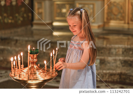 A little girl puts a candle in church. Orthodoxy A little girl puts a candle in church. Orthodoxy 113242701