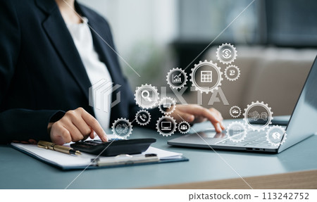 Female businessman working on desk office with using a calculator to calculate the numbers, finance accounting concept. Female businessman working on desk office with using a calculator to calculate the numbers, finance accounting concept. 113242752