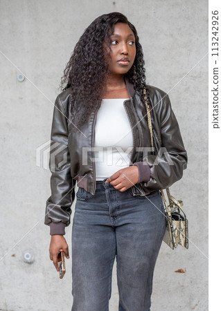 Confident Young Woman in Casual Fashion Posing Against Concrete Wall Confident Young Woman in Casual Fashion Posing Against Concrete Wall 113242926