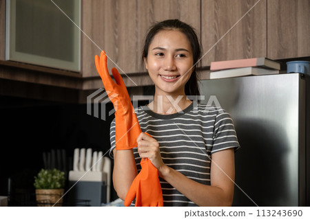 Portrait of young smiling housewife wearing rubber gloves. Ready to clean 113243690