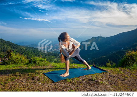 Woman practices yoga asana Utthita Parsvakonasana 113244607