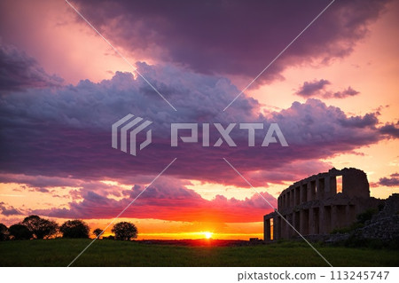 The sun sets over an old, abandoned building. 113245747
