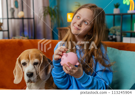 Preteen child girl kid putting dollar pocket money cash into piggybank saving for future education 113245904