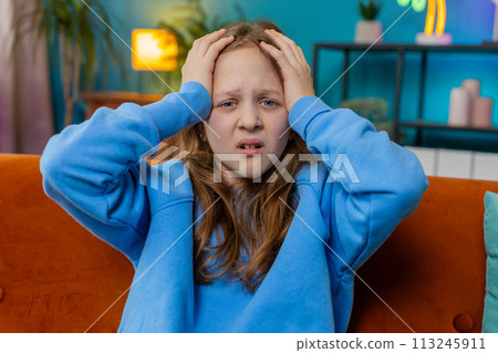 Sad depressed child girl at home looks pensive thinks over life concerns or study test exam fail 113245911