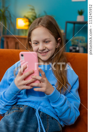 Child girl text share messages on smartphone social media applications online watching relax movie 113245952