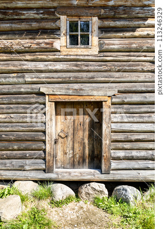 Door and small window in old wooden log house 113246329