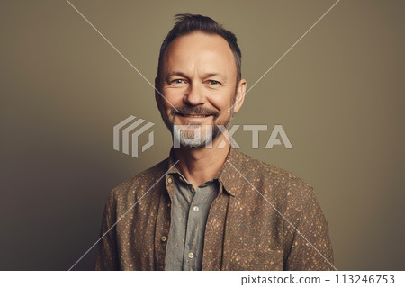 A man with a beard and a smile is wearing a brown shirt 113246753