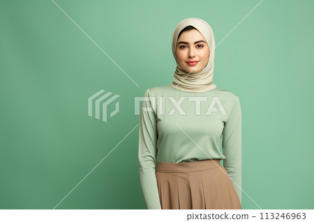 A woman wearing a green shirt and brown skirt with a white scarf on her head 113246963