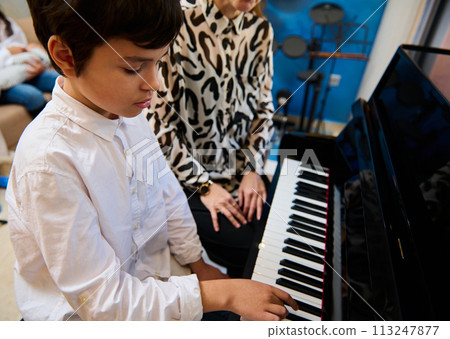 Confident talented teenage musician plays piano forte, creates music and song composes a melody during music lesson 113247877