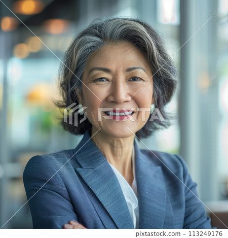 Smiling Asian businesswoman 50-60 years old, active business woman against the background of her office 113249176