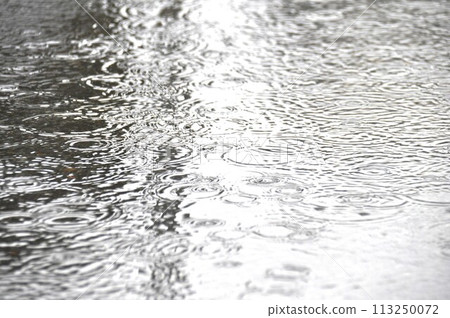 雨水打在柏油路上的水窪上泛起漣漪 113250072
