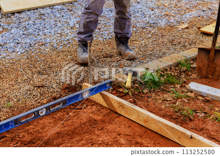 Formwork for pouring of concrete on foundation is produced by workers using templates removable timbers Formwork for pouring of concrete on foundation is produced by workers using templates removable timbers 113252580