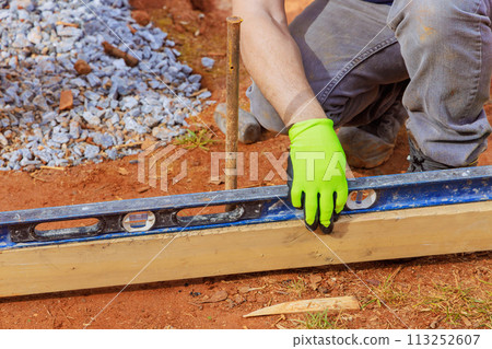 Using removable timbering to construct concrete base foundation for house 113252607