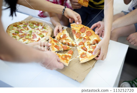 Delicious pizza close-up cut into pieces on white table. 113252720