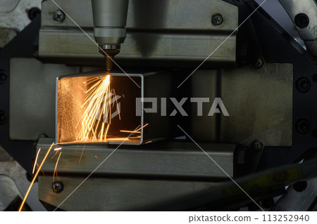 Close up scene the fiber laser cutting machine cut the square shape stainless steel tube with sparkling light. 113252940