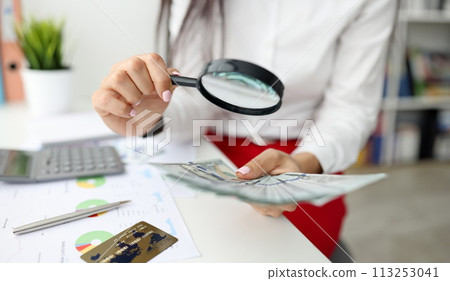 Woman check currency for authenticity. 113253041
