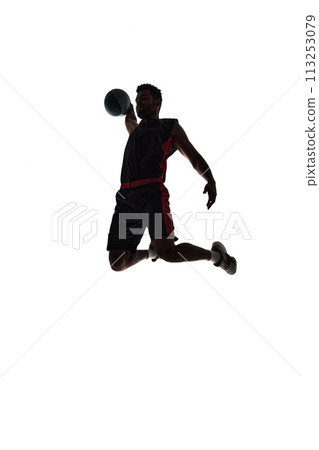 Slam dunk. Silhouette of young man, basketball player in motion during game throwing ball into basket isolated on white background Slam dunk. Silhouette of young man, basketball player in motion during game throwing ball into basket isolated on white background 113253079